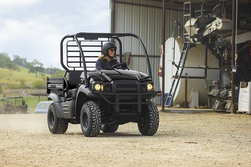 Front angle of a person driving a side x side on a ranch. opens in a new window