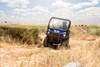 Front angle of a person driving a side x side on a ranch.