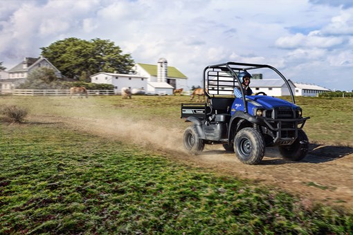 Three-quarter front angle of a person driving a side x side on a ranch. opens in a new window