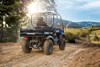 Three-quarter rear angle of a person driving a side x side on a ranch.