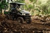 Profile angle of two people driving a side x side off-road.