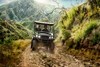 Front angle of two people driving a side x side off-road.