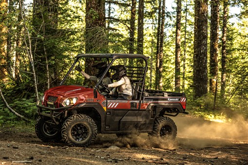 Side angle of two people driving a side x side off-road. opens in a new window