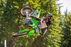 Side angle of a person riding a motorcycle, whipping in midair.