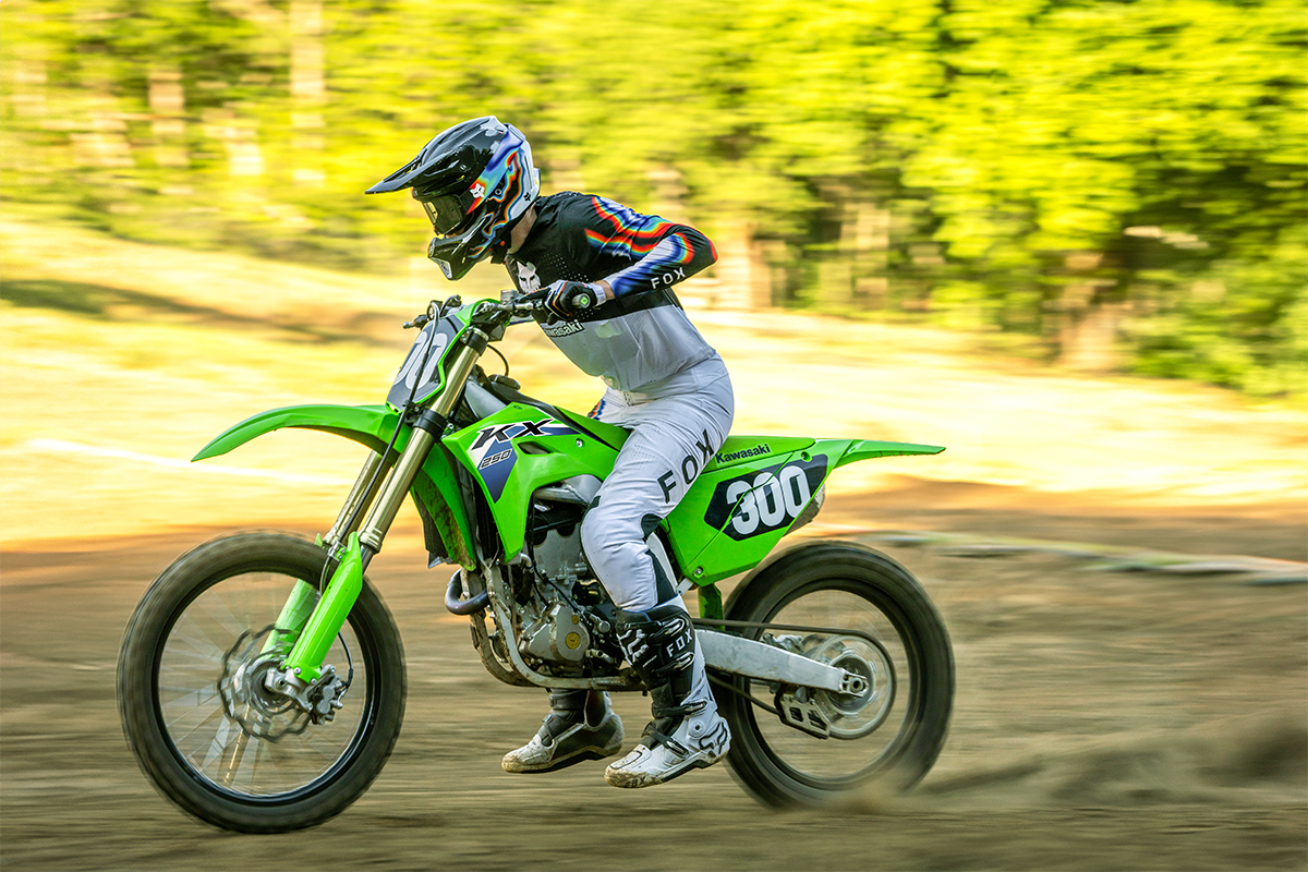 Side angle of a person riding a motorcycle on a dirt track.
