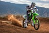 Three-quarter front angle of a person riding a motorcycle on a dirt track.