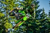 Side angle of a person riding a motorcycle, whipping in midair.