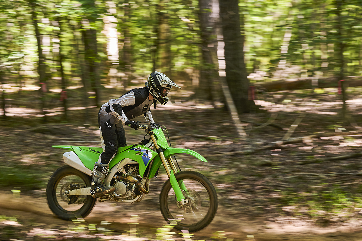 Side angle of a person riding a motorcycle on an off-road course.