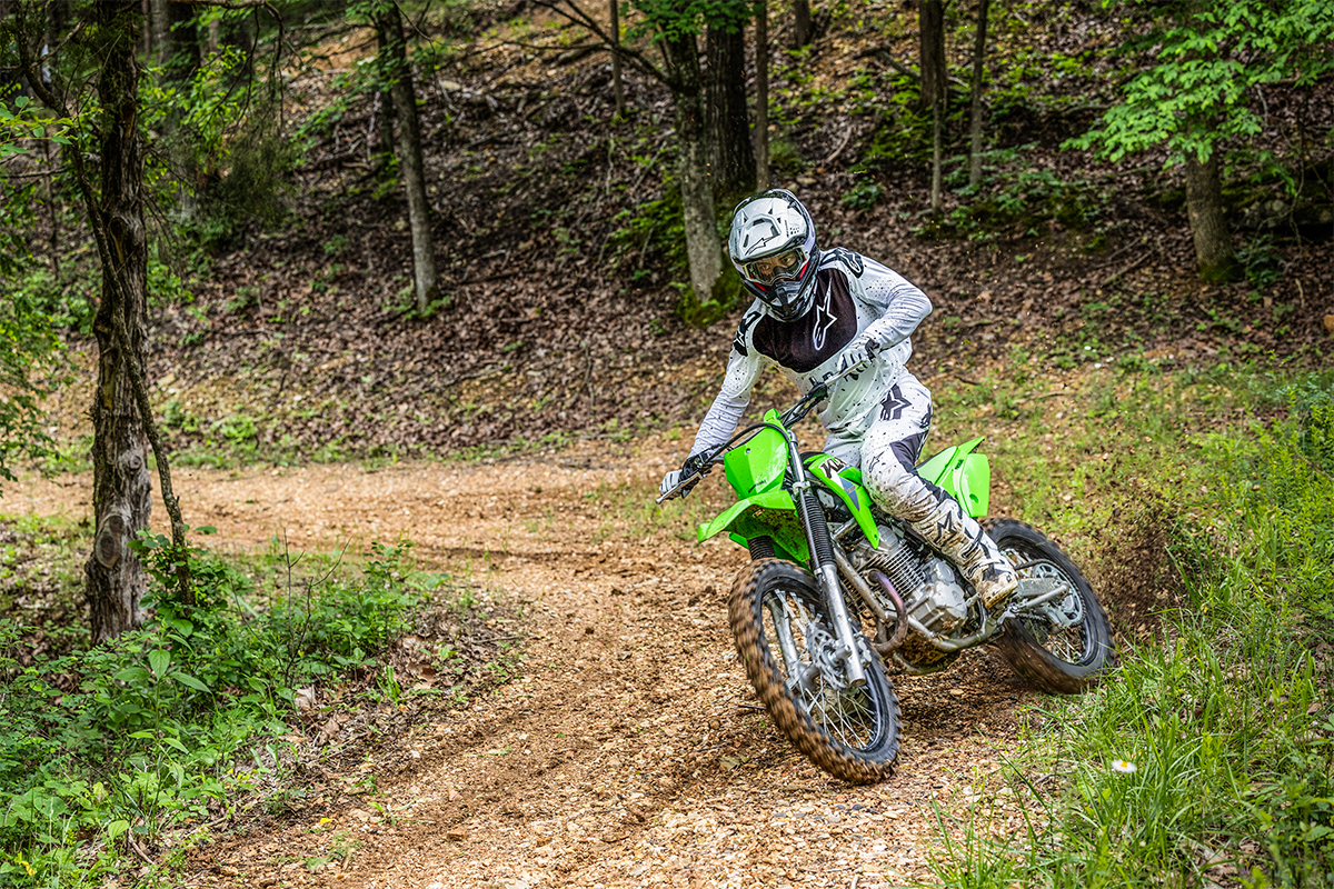 Three-quarter front angle of a person riding a motorcycle off-road.
