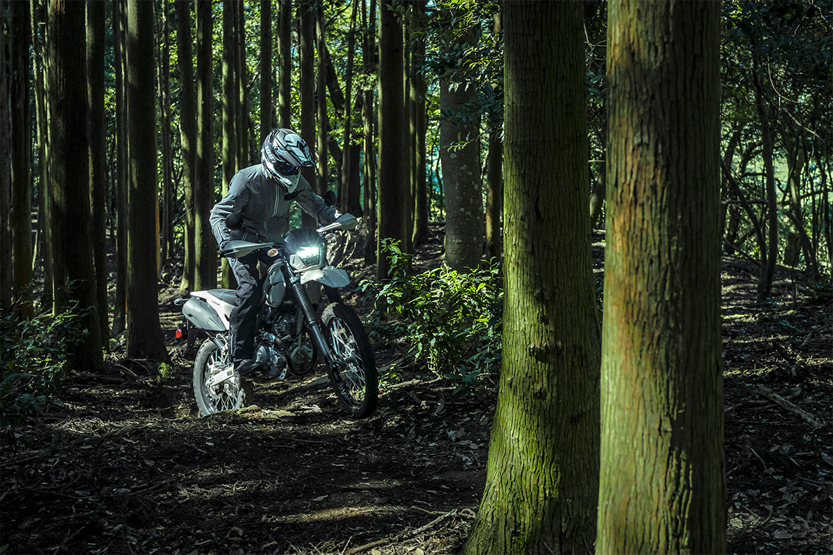 Three-quarter front angle of a person riding a motorcycle off-road.