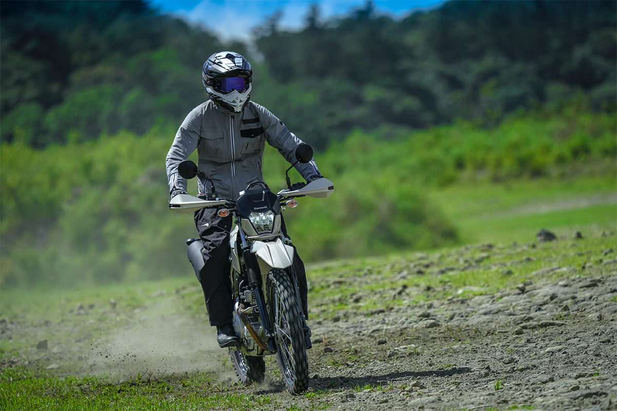 Front angle of a person riding a silver motorcycle off-road.