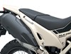 Close-up view of the seat and exhaust of a motorcycle staged in a white studio background.
