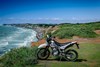 Side angle of a motorcycle parked off-road.