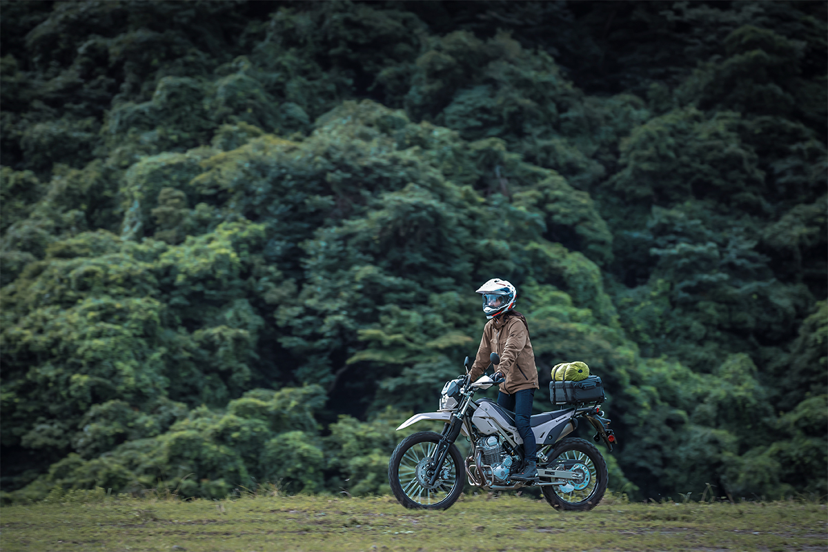 Side angle of a person riding a motorcycle off-road.