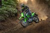 Three-quarter front angle of a person riding a motorcycle off-road.