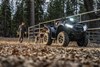 Three-quarter front angle of an ATV parked near a horse paddock.