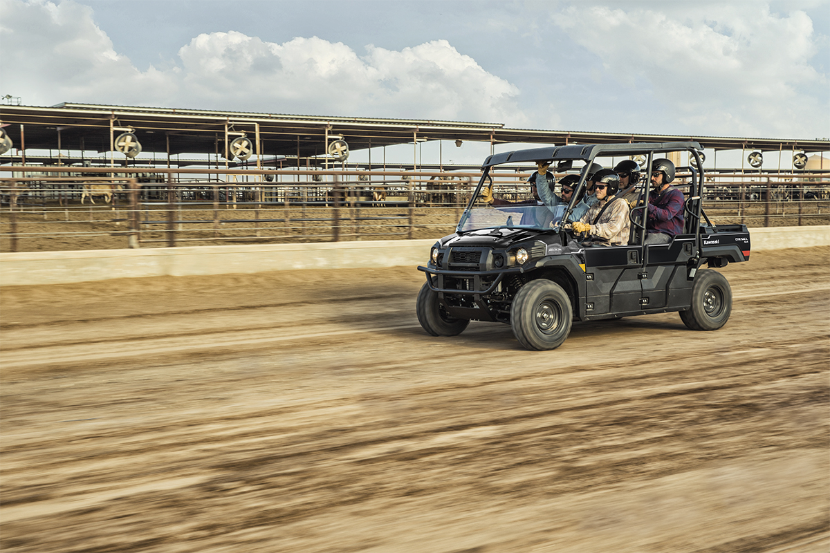 Three-quarter front angle of six people riding in a side x side at a jobsite.