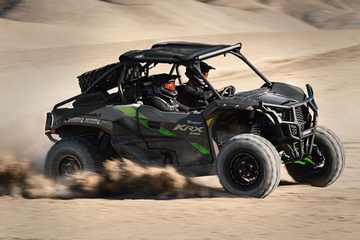 Side angle of two people driving a black side x side off-road. opens in a new window