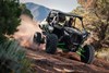 Front angle of two people driving a side x side off-road.