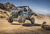 Three-quarter front angle of a person riding a side x side off-road.