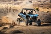 Three-quarter front angle of a person riding a sport side x side off-road.