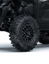 Close-up view of the front-left tire of a side x side staged in a white studio background.
