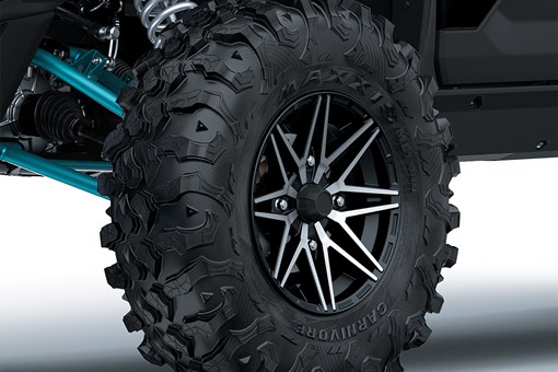 Close-up view of the front left tire of a side x side staged in a white studio background. opens in a new window