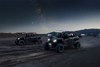 Three-quarter front angle of two parties driving separate side x sides off-road.