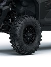 Close-up view of the front-left tire of a side x side staged in a white studio background.
