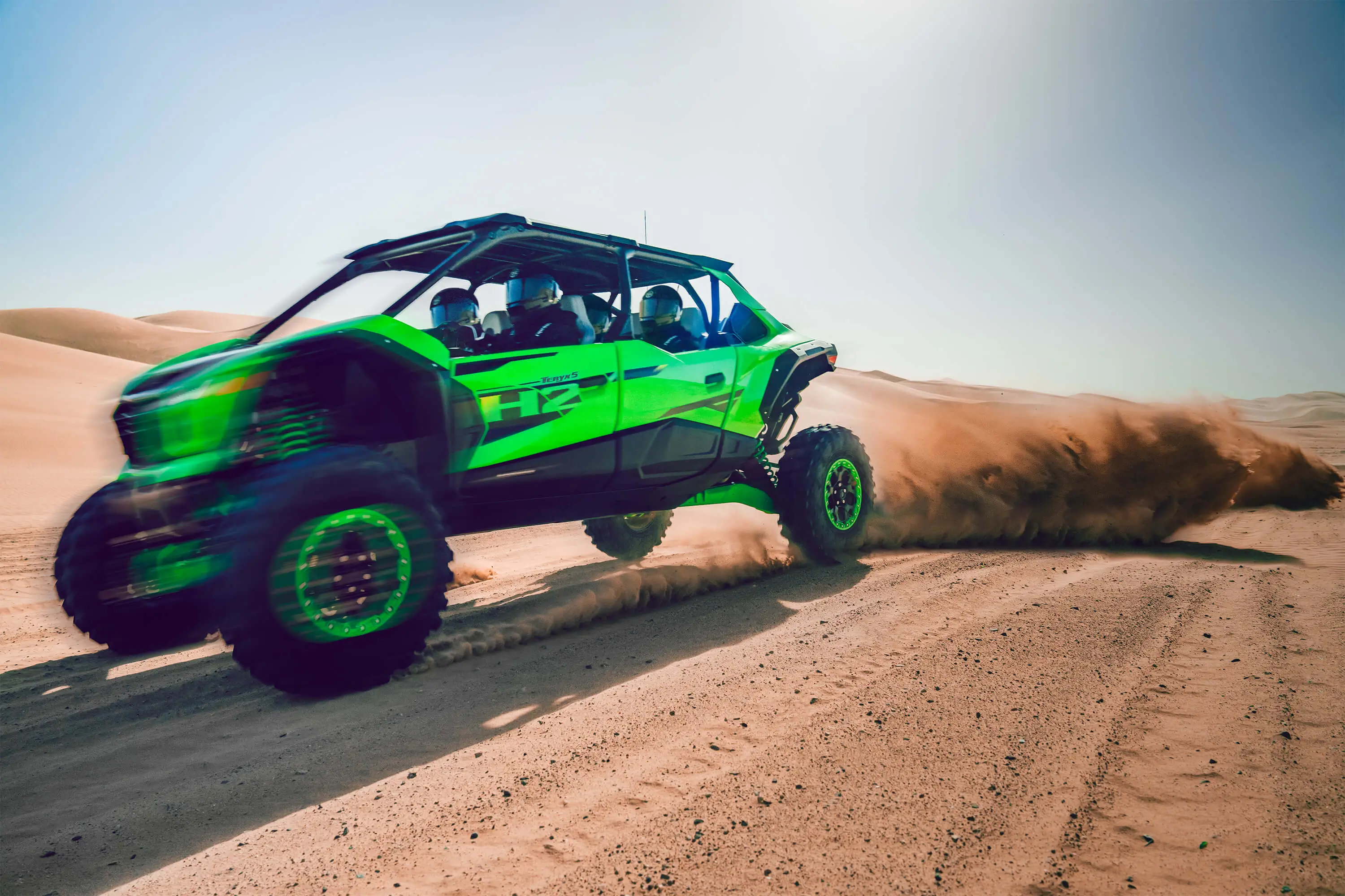 Side angle of a person driving a side x side off-road very fast.