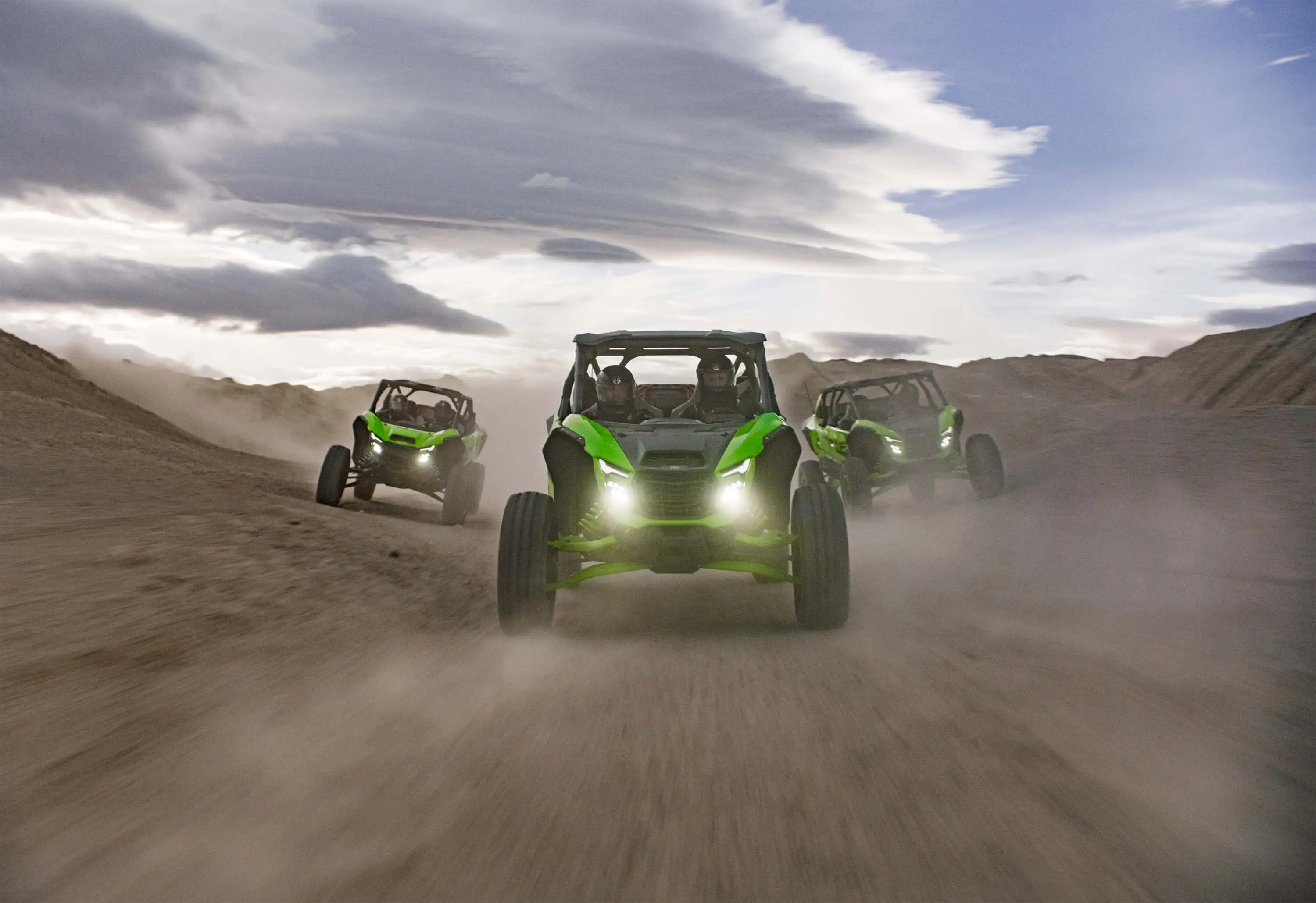 Front angle of 3 side x sides driving off-road.