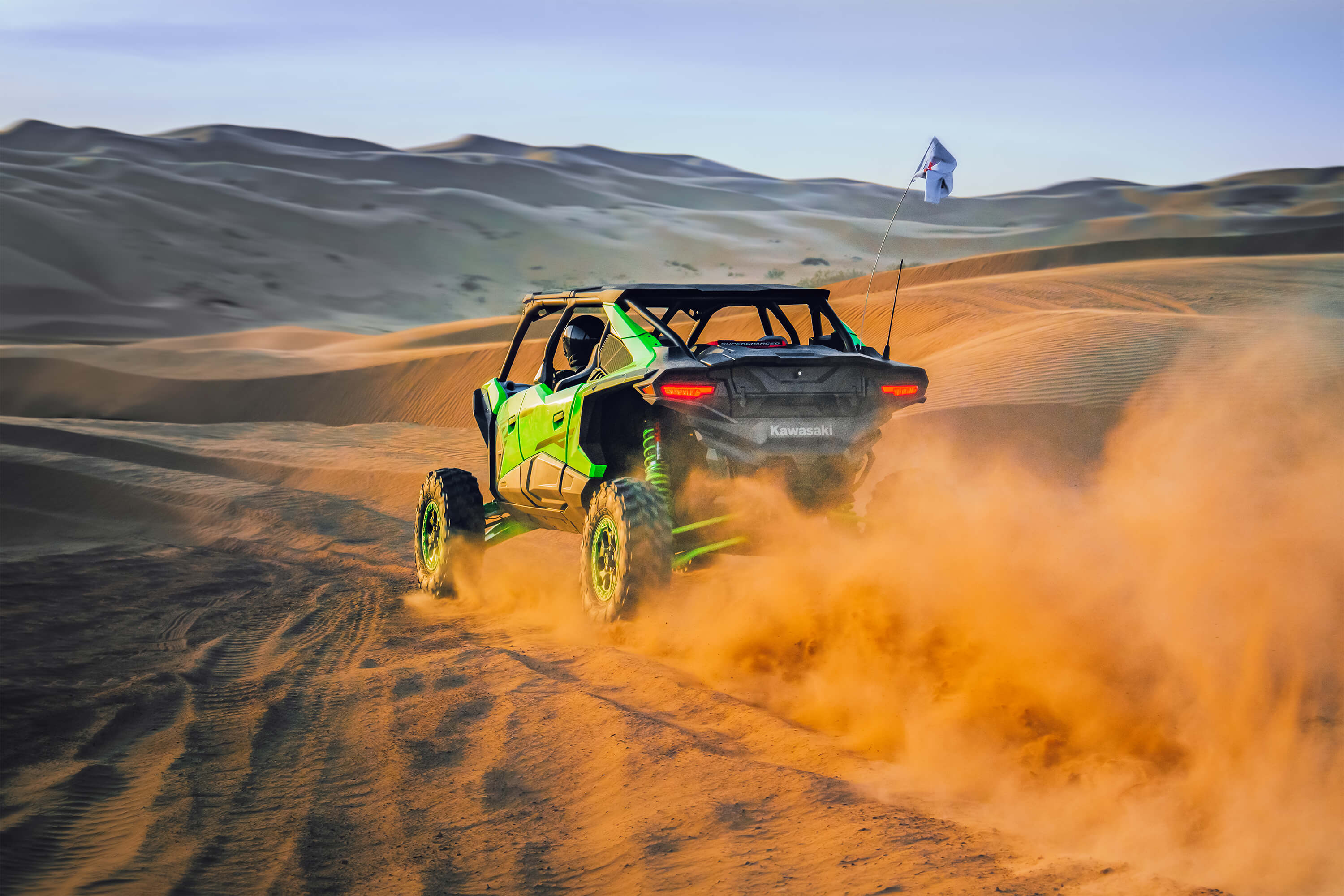 Rear angle of a person driving a side x side off-road.