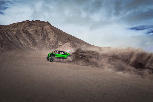 Side angle of a person driving a side x side off-road. opens in a new window