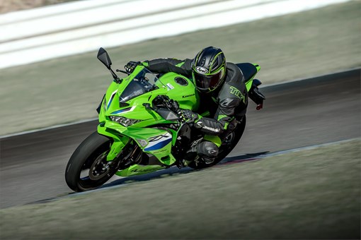 Three-quarter front angle of a person riding a motorcycle on a racetrack. opens in a new window