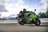 Side angle of a person riding a motorcycle on a racetrack.