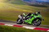 Side angle of a person riding a motorcycle on a racetrack.