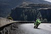 Front angle of a person riding a motorcycle on a road.