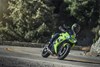 Three-quarter front angle of a person riding a motorcycle on a curvy road.