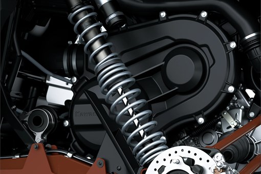 Close-up view of the suspension, brake system, and engine compartment of a side x side staged in a white studio background. opens in a new window