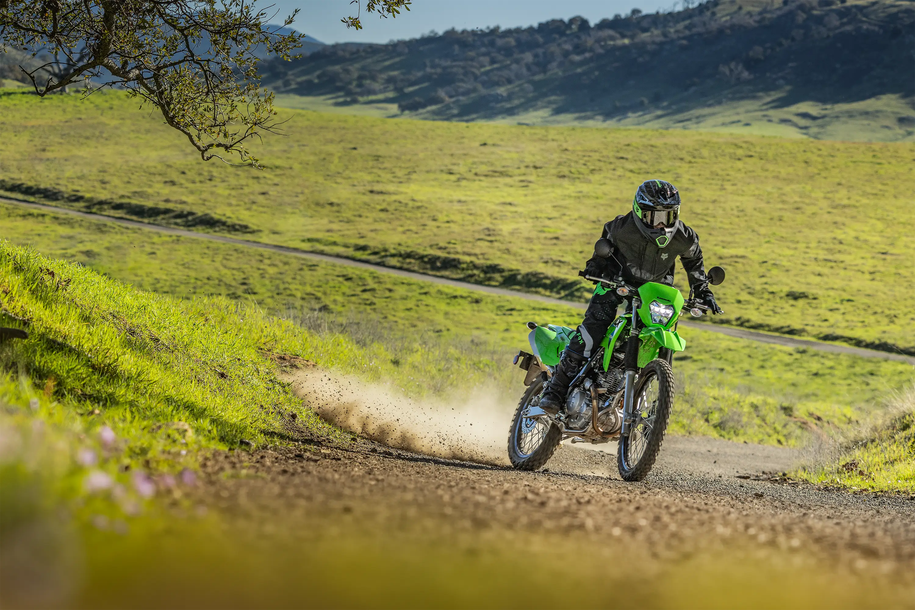 Side angle of a person riding a motorcycle off-road.