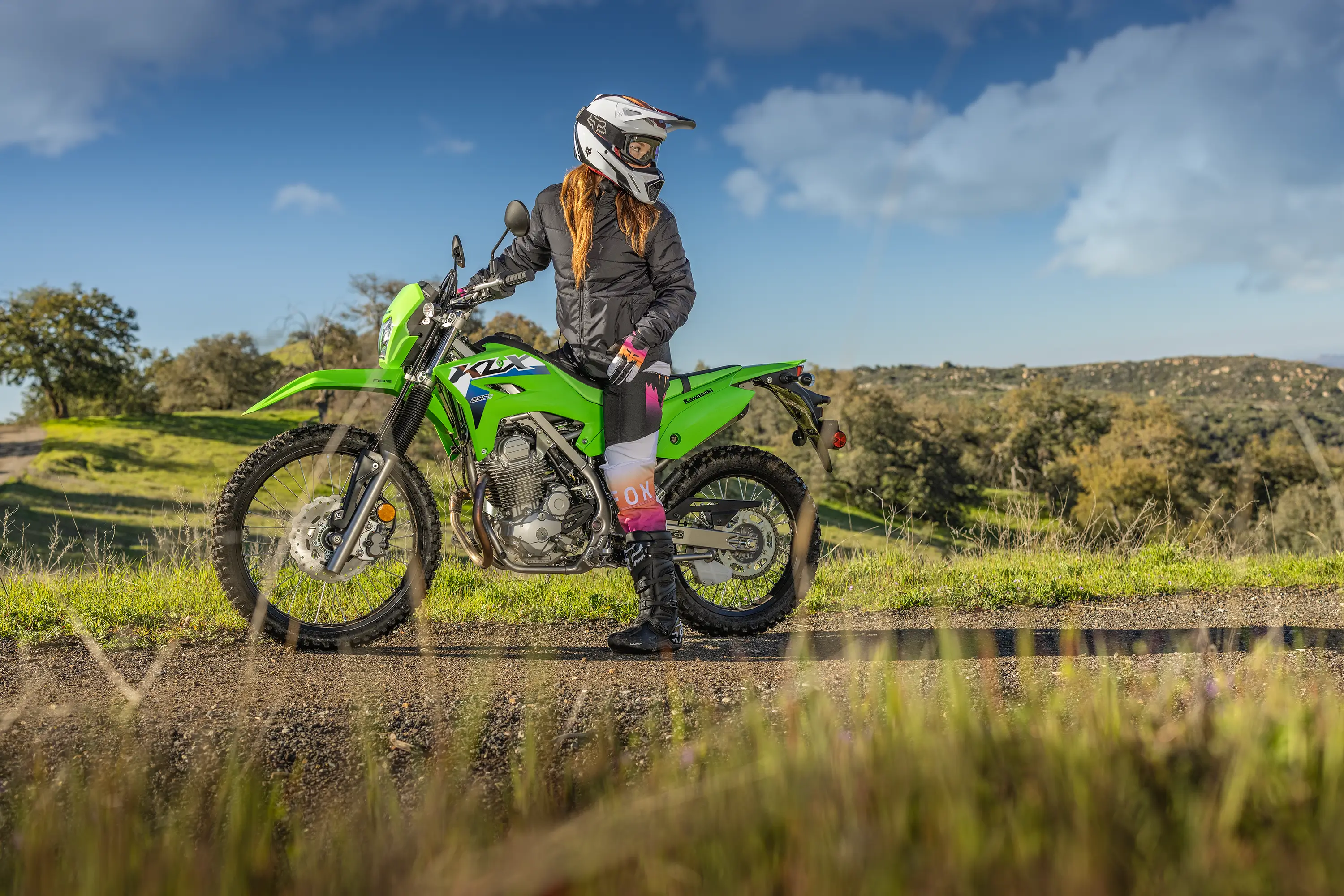 Side angle of a person parked on a motorcycle off-road.