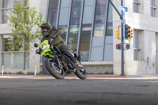 Three-quarter front angle of a person turning a motorcycle on the street. opens in a new window