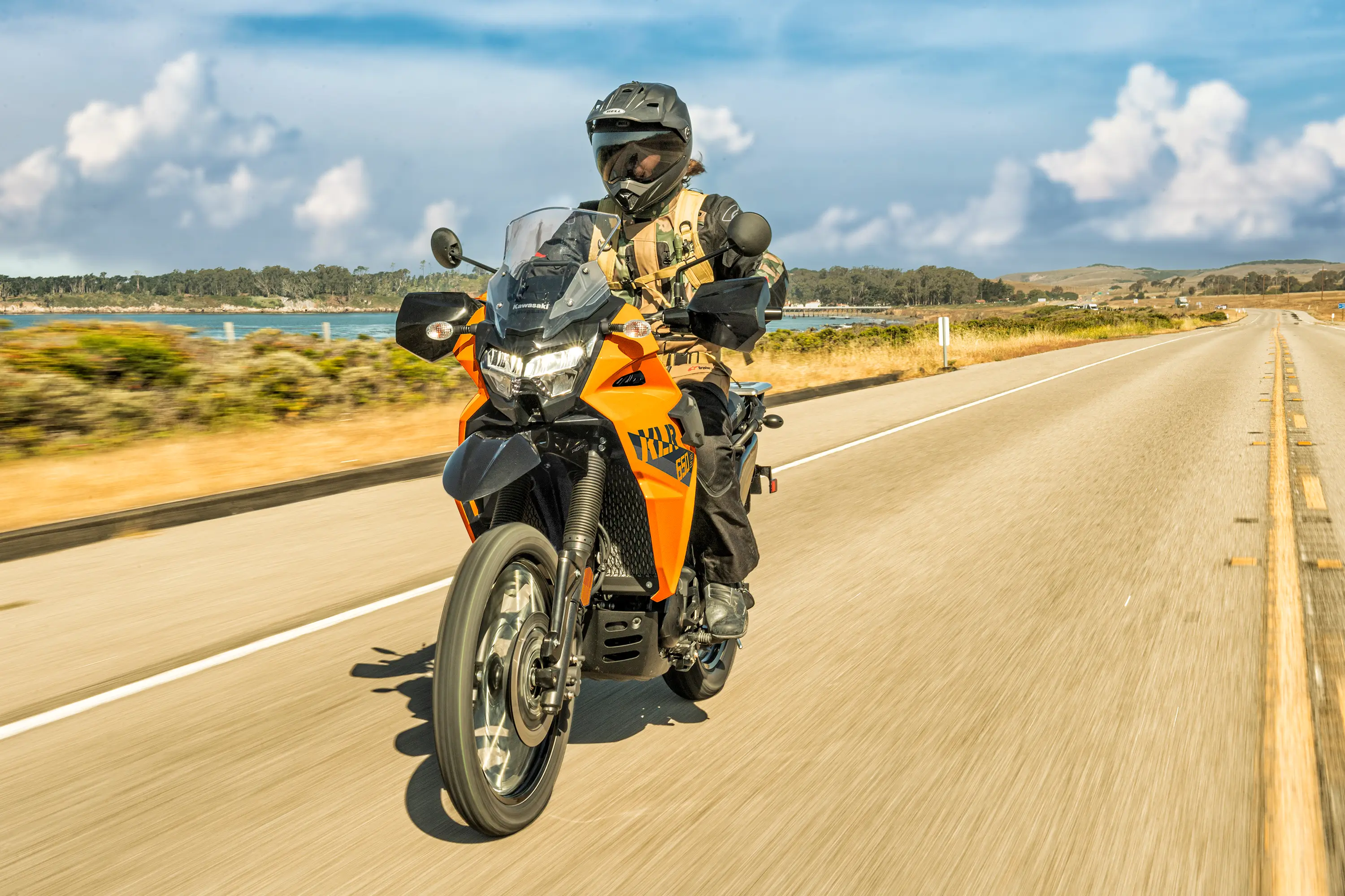 Three-quarter front angle of a person riding a motorcycle on a highway.