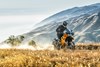 Three-quarter front low down angle of a person riding a motorcycle off-road.