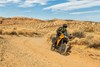 Three-quarter front angle of a person riding a motorcycle around a corner off-road.
