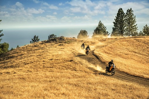 Three-quarter front angle of 3 people riding motorcycles off-road. opens in a new window