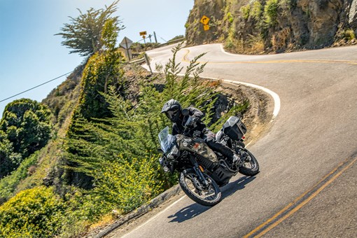 Three-quarter front angle of a person riding a motorcycle on a highway. opens in a new window
