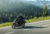 Side angle of two people riding a motorcycle on a highway.