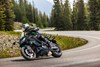 Three-quarter front angle of a person riding a motorcycle on a highway.
