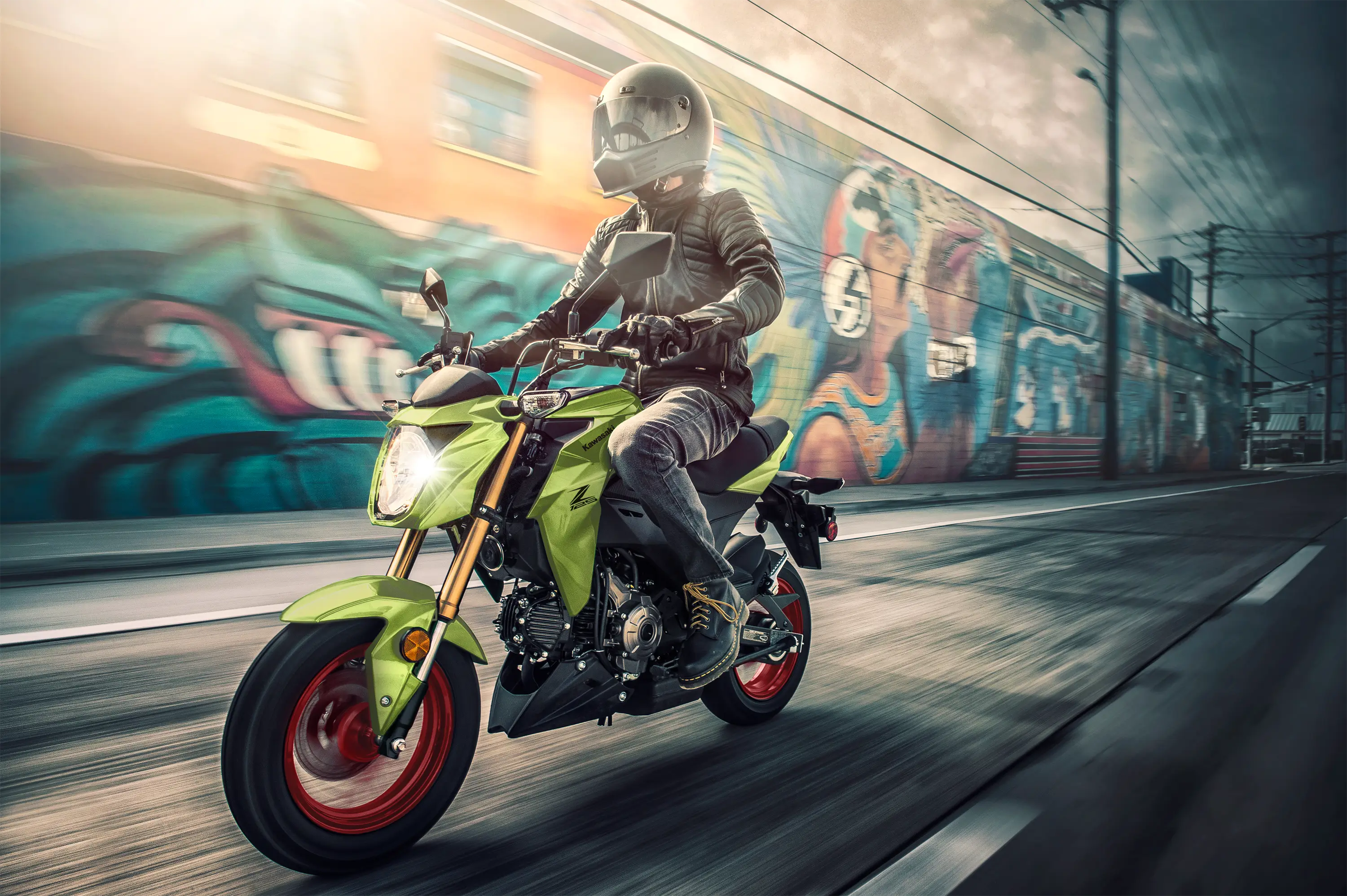 Three-quarter front angle of a person riding a motorcycle on the street.
